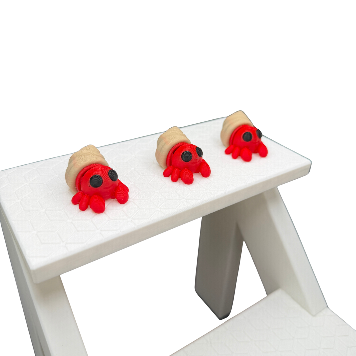 Side profile of 3D printed hermit crab showing spiral shell detail and black eyes