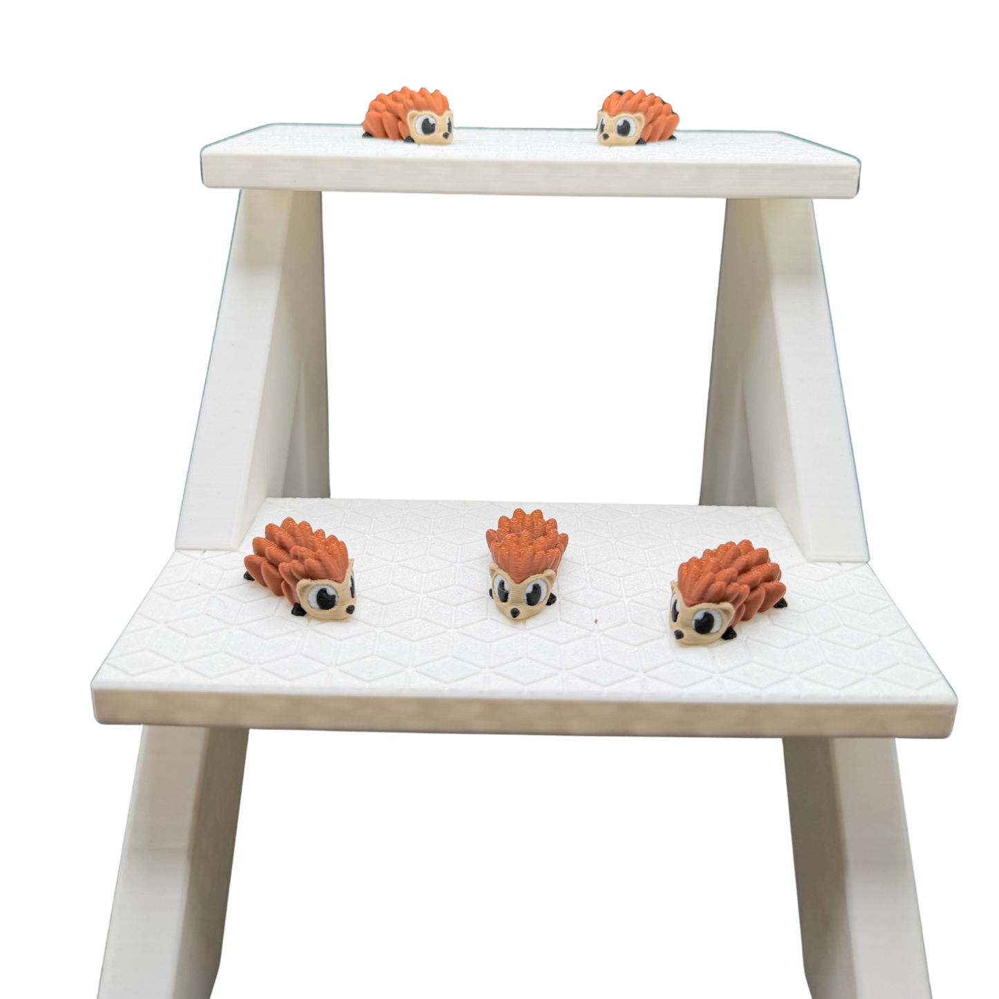  3D printed hedgehog desk pet displayed on white shelf next to other small figures
