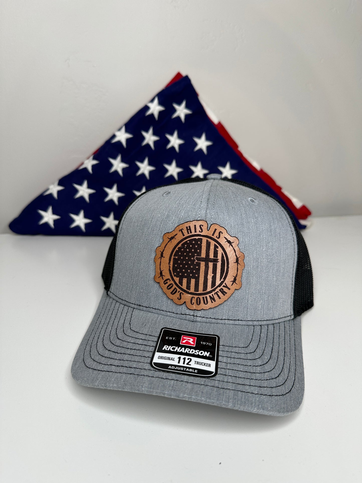 Richardson 112 God's Country hat displayed with folded American flag patriotic gift