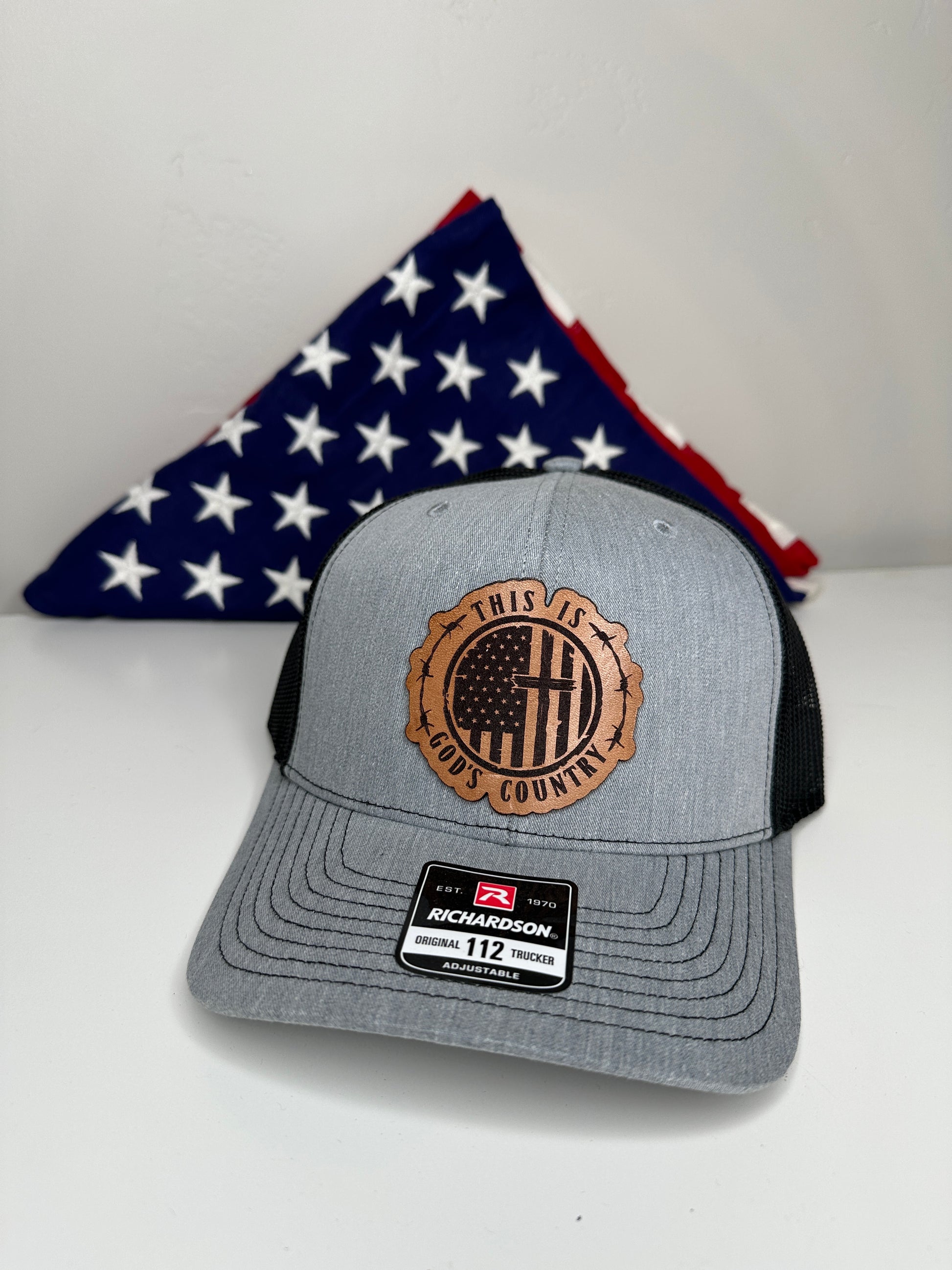 Richardson 112 God's Country hat displayed with folded American flag patriotic gift